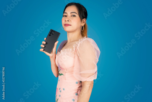 Beautiful woman standing with her left hand holding the phone