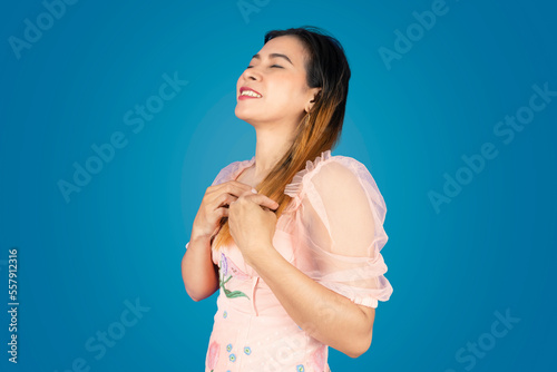 A beautiful woman stands with both hands on her chest and closes her eyes.
