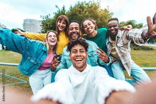 Multiracial group of friends taking selfie picture walking on city street - Happy young people smiling together at camera outside - University students having fun in college campus - Youth culture