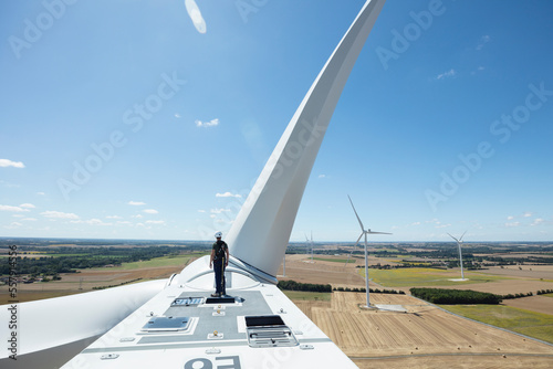 man on top of a wind turbine photo