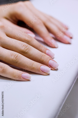 Hands of young woman with clean manicure on white background closeup
