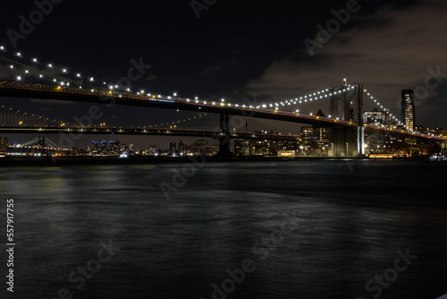 Brooklyn bridge crossing into Brooklyn at night with epic lights