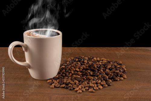 Coffee beans standing on wooden floor and hot coffee in mug 