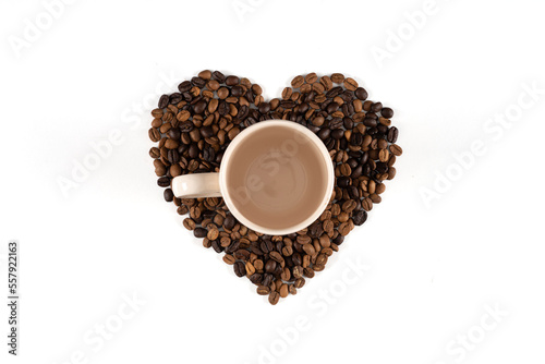 Heart-shaped coffee beans on a white background, a coffee mug on coffee beans