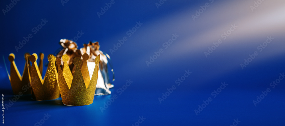 Happy Epiphany Day, Three Kings Day greeting card with three gold crowns and gifts on blue background. Concept for Dia de Reyes Magos day, three Wise Men, Epiphany Christian feast day - obrazy, fototapety, plakaty 
