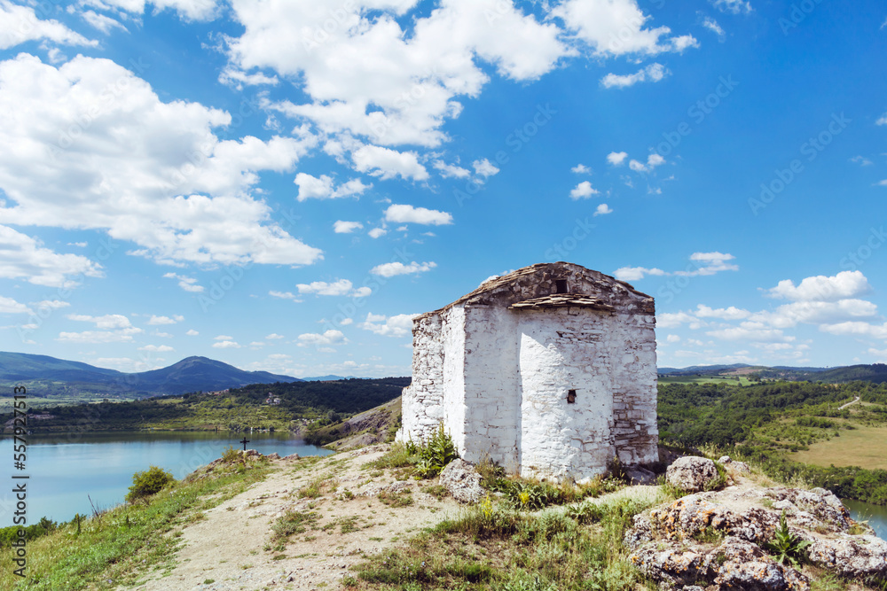 White stone chapel on a rocks with lake view . Saint Joan Letni Church, Pchelina lake ,Bulgaria 
