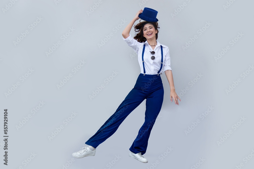 happy asian girl dancing with top hat, white shirt and blue jumper with sneaker