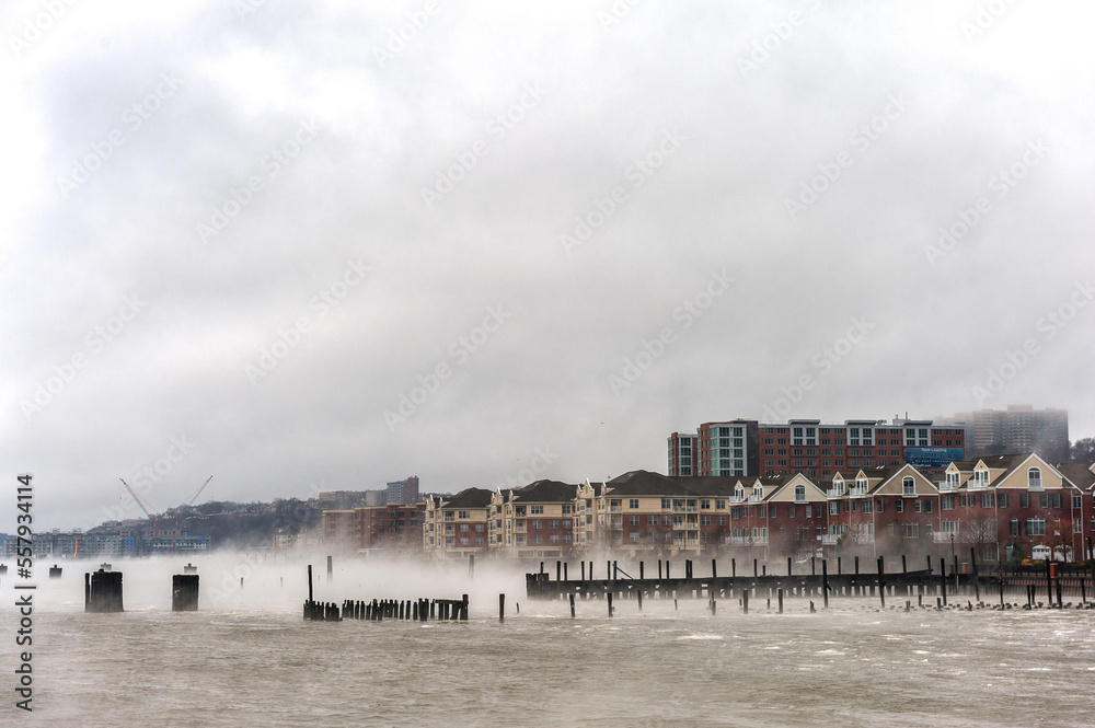 Hudson river in Winter with Misty Edgewater Cityscape in Background. New Jersey, USA
