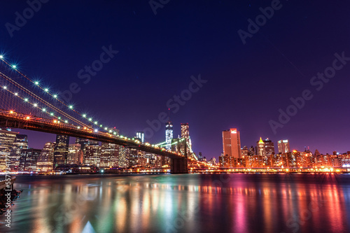 Fototapeta Naklejka Na Ścianę i Meble -  Brooklyn Bridge at Night. Long Exposure. New York. NYC, USA. Lights Reflection on Water.