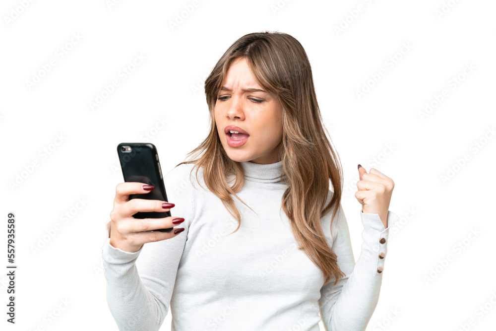 Young girl over isolated chroma key background using mobile phone and doing victory gesture Young girl over isolated chroma key background using mobile phone and doing victory gesture