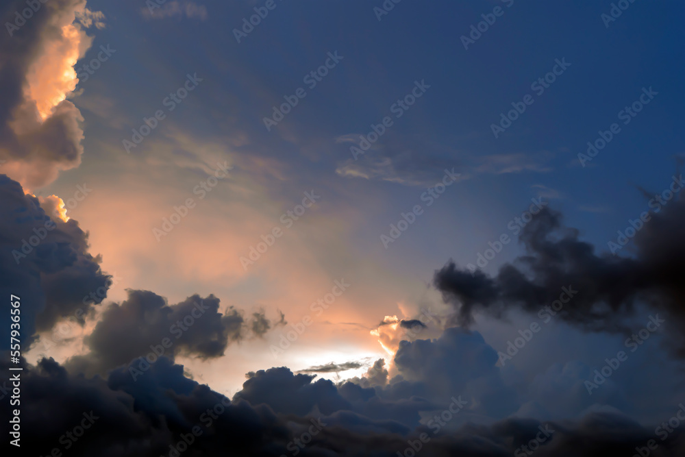 Majestic dramatic sunset sky with large and dark rain clouds in evening time over the tropical region in Ubud, Indonesia. Stormy cloudy sky.