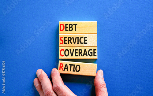 DSCR debt service coverage ratio symbol. Concept words DSCR debt service coverage ratio on wooden block on beautiful blue background. Business DSCR debt service coverage ratio concept. Copy space. photo