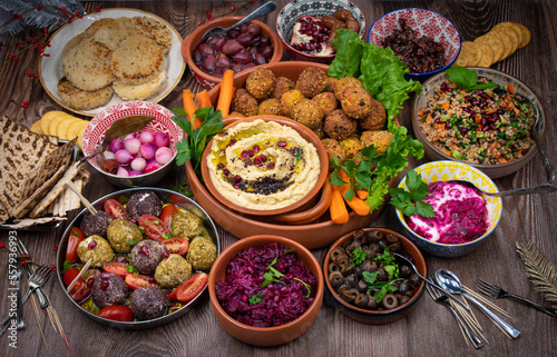 Vegetarian mezze spread consisting of falafel, crudites, cheese, olives and pickles photo