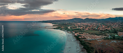 Fototapeta Naklejka Na Ścianę i Meble -  San Teodoro sand beach and village at coastline in Sadinia Italy from above during sunset, clouds in sky
