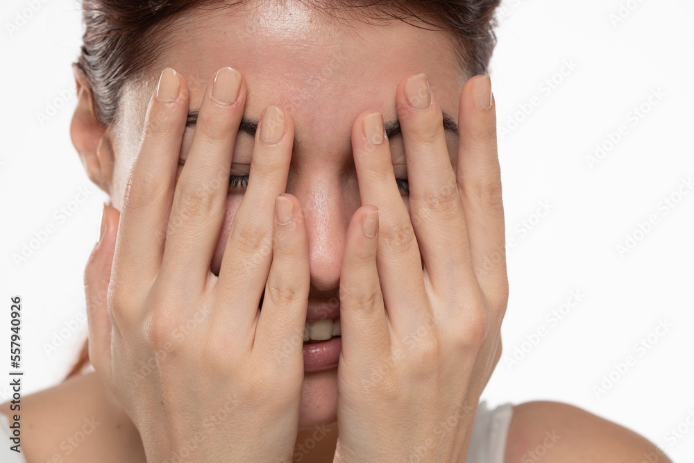 Portrait of yong happy ashamed woman, covering face with hands, beautiful model posing in studio over white background Portrait of yong happy ashamed woman, covering face with hands, beautiful model posing in studio over white background