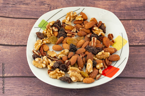 Nuts on a plate with almonds, walnut, brown raisin and blonde raisin