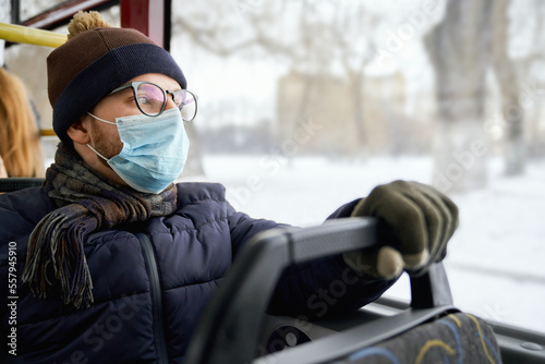 Canvas Print Side view of passenger traveling by bus during global pandemic, wearing medical mask, protecting