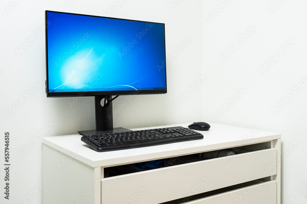 Fototapeta premium Desktop computer on white table in white walled room