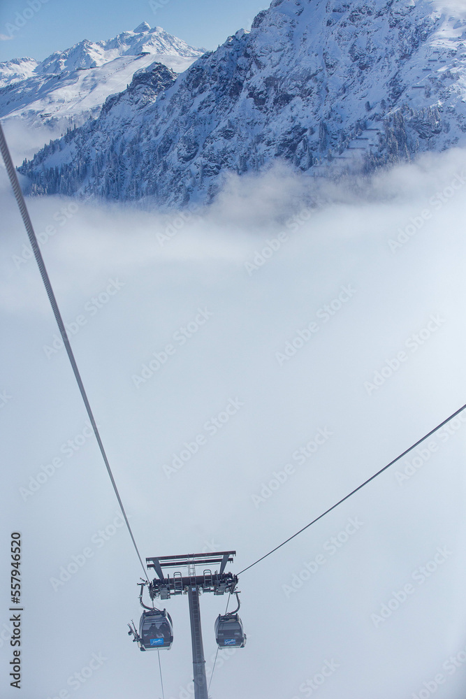 Obraz premium ski lift in the mountains above the clouds
