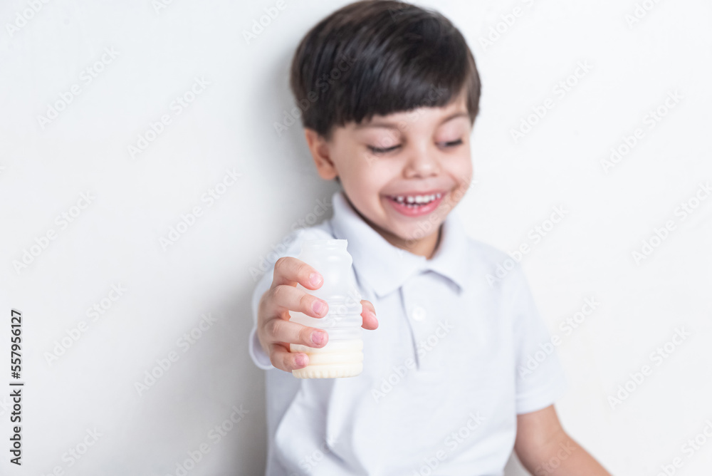 Cute boy in white shirt on white background - drinking fermented milk Cute boy in white shirt on white background - drinking fermented milk
