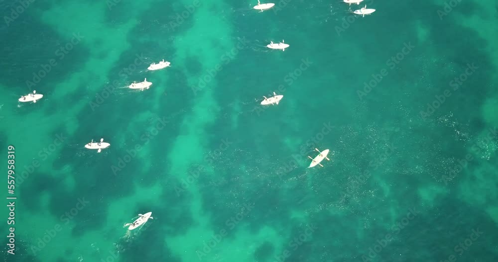 Aerial view of kayakers traversing a stretch of open aqua sea