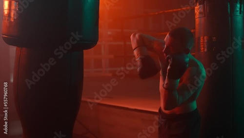 Boxer in the boxing gym. Bandages his hands. Sparring in the ring. Boxer jumping rope. Exercise with ropes. Round one. Fog in the ring. Zetsky sport. Beautiful backlight. World boxing champion.

 photo