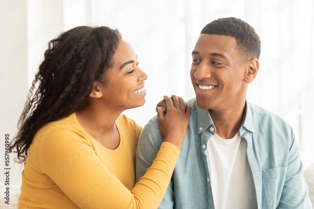 Lifestyle, romantic and date at home. Smiling pretty millennial african american wife looking at husband Lifestyle, romantic and date at home. Smiling pretty millennial african american wife looking at husband