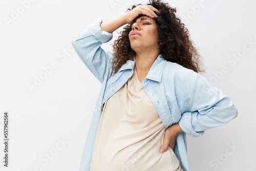 Pregnant woman fatigue back pain and headache on white isolated background in t-shirt with blue shirt