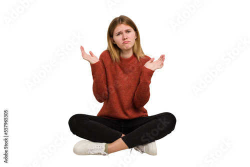Young caucasian woman sitting on the floor cutout isolated