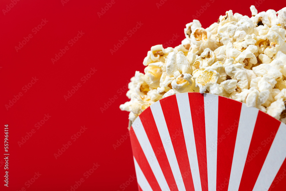 Salted popcorn on red background. Copy space. Close up