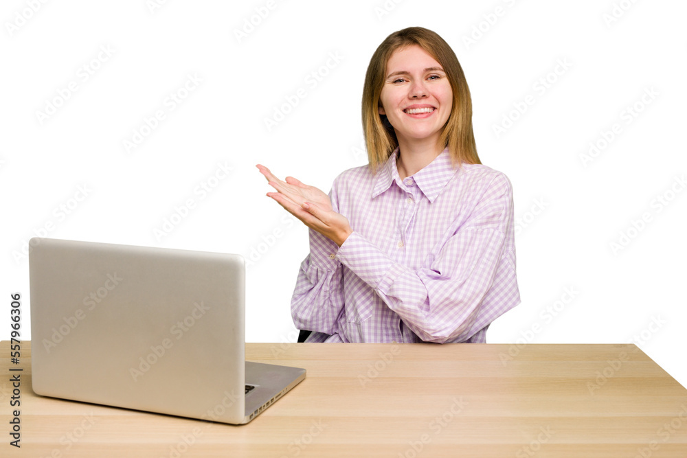 Young caucasian woman in a workplace working with a laptop isolated holding a copy space on a palm. Young caucasian woman in a workplace working with a laptop isolated holding a copy space on a palm.