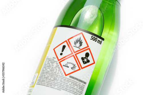 A green bottle of highly corrosive flammable chlorinated rubber nitro solvent with printed on warning symbols label, sticker. Dangerous chemical substances abstract concept, closeup, detail, nobody photo