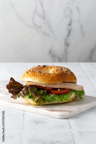 bagel with ham and vegetables on a white background