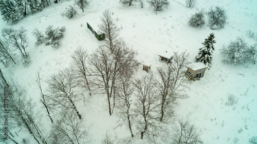 Aerial drone shot of an off-grid cargo container and bunkie in the snow during winter photo