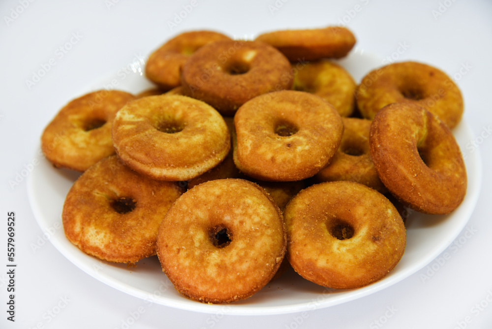 Round shortbread cookies on a plate. Soft sweet cake on a white background. A sweet snack. Round shortbread cookies on a plate. Soft sweet cake on a white background. A sweet snack.