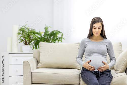 Photo of pregnant woman hugging her stomach