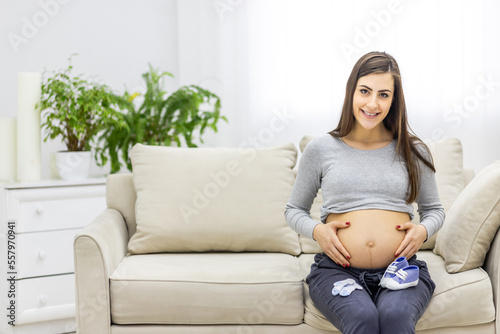 Photo of pregnant woman touching her stomach.
