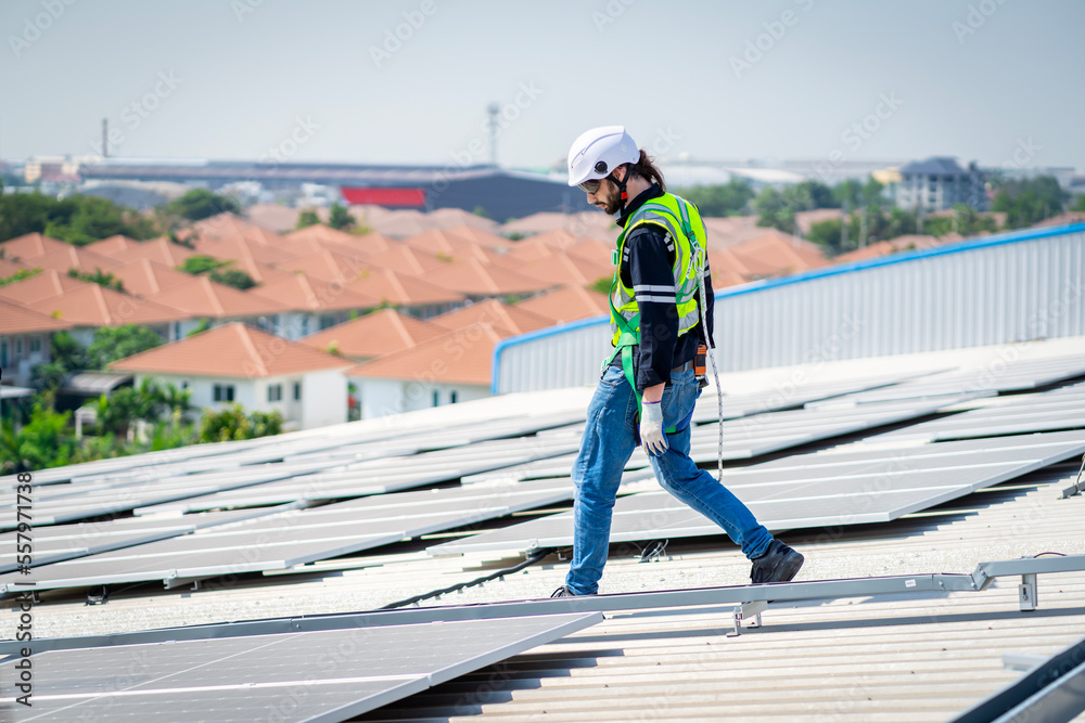 Male engineer installing or checking the working condition of solar panels on the roof or at the height of the factory for saving electricity was broken to use renewable energy from the sun Male engineer installing or checking the working condition of solar panels on the roof or at the height of the factory for saving electricity was broken to use renewable energy from the sun