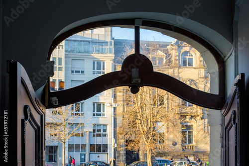 View of French apartment building seen through the open gate with ornate wooden doors