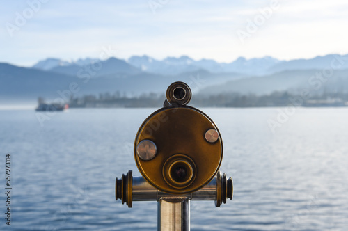 a telescope on the pier with alps view