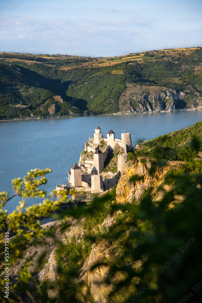 Old fortified castle by the sea fjord in summer sunset, historical ancient fortification rock palace tower