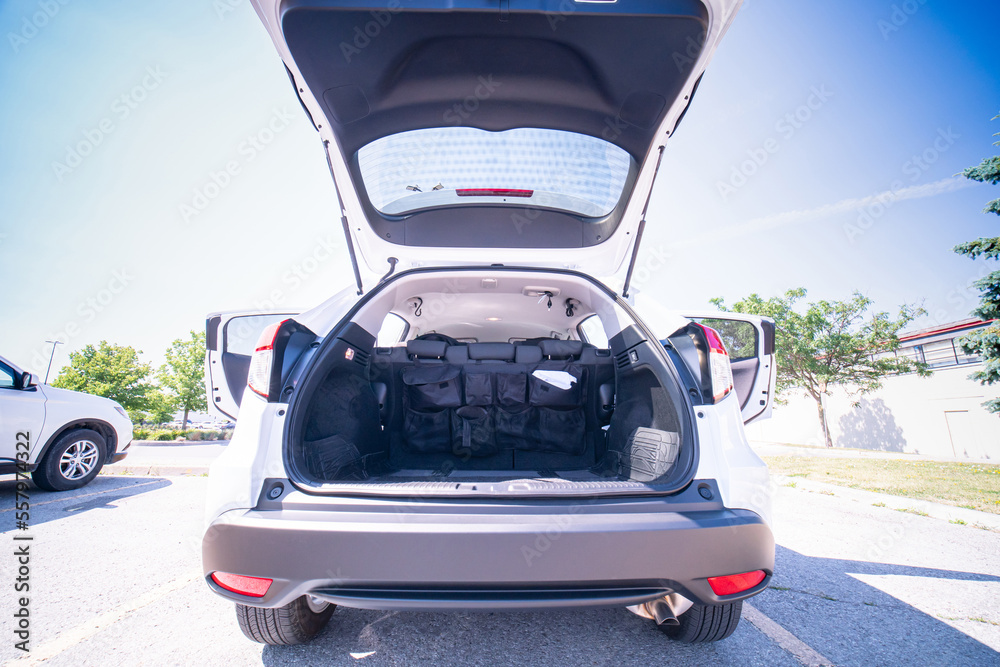 Empty car trunk open view with backseat car organizer with storage pockets. Modern hatchback SUV vehicle open cargo area. The automobile boot is open for luggage. Preparation for travel concept. - obrazy, fototapety, plakaty 