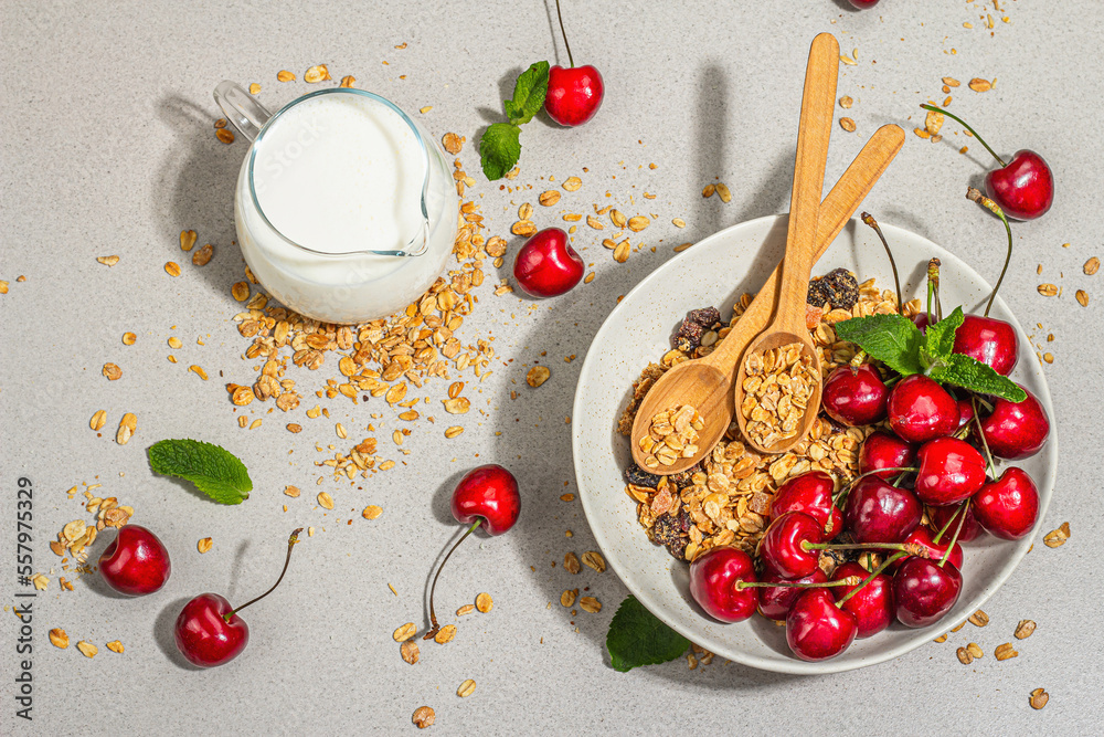 Summer breakfast concept. Healthy morning food. Ripe cherries and granola, light concrete background Summer breakfast concept. Healthy morning food. Ripe cherries and granola, light concrete background