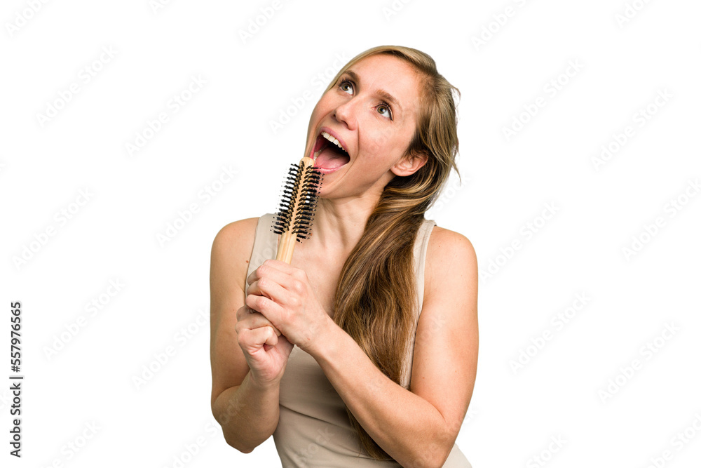 Young caucasian woman using an hair comb isolated Young caucasian woman using an hair comb isolated