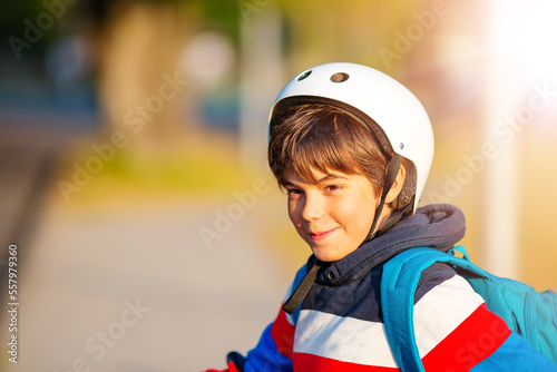 Cute boy in helmet standing and smiling at photocamera. photo