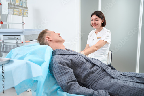Gladsome gentleman conversating with his healthcare practitioner photo