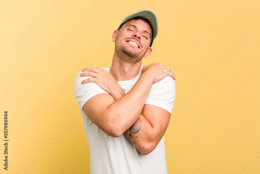 Young caucasian handsome man isolated on yellow background hugs, smiling carefree and happy. Young caucasian handsome man isolated on yellow background hugs, smiling carefree and happy.