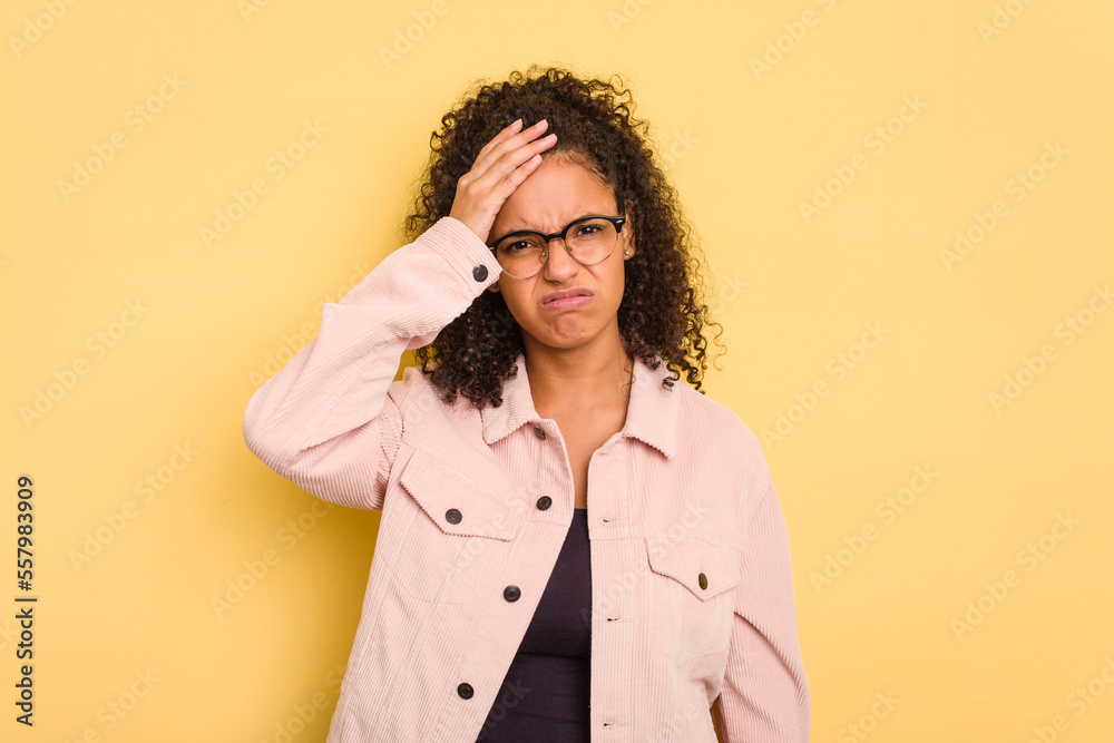 Young Brazilian curly hair cute woman isolated on yellow background tired and very sleepy keeping hand on head. Young Brazilian curly hair cute woman isolated on yellow background tired and very sleepy keeping hand on head.