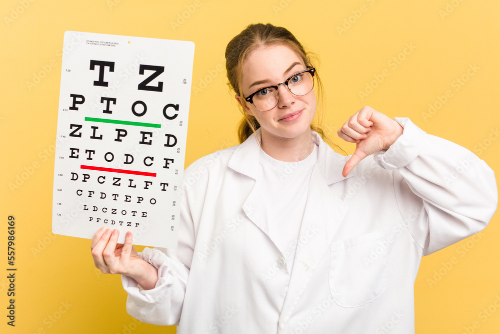 Young caucasian oculist woman holding a eye chart paper isolated on yellow background feels proud and self confident, example to follow. Young caucasian oculist woman holding a eye chart paper isolated on yellow background feels proud and self confident, example to follow.