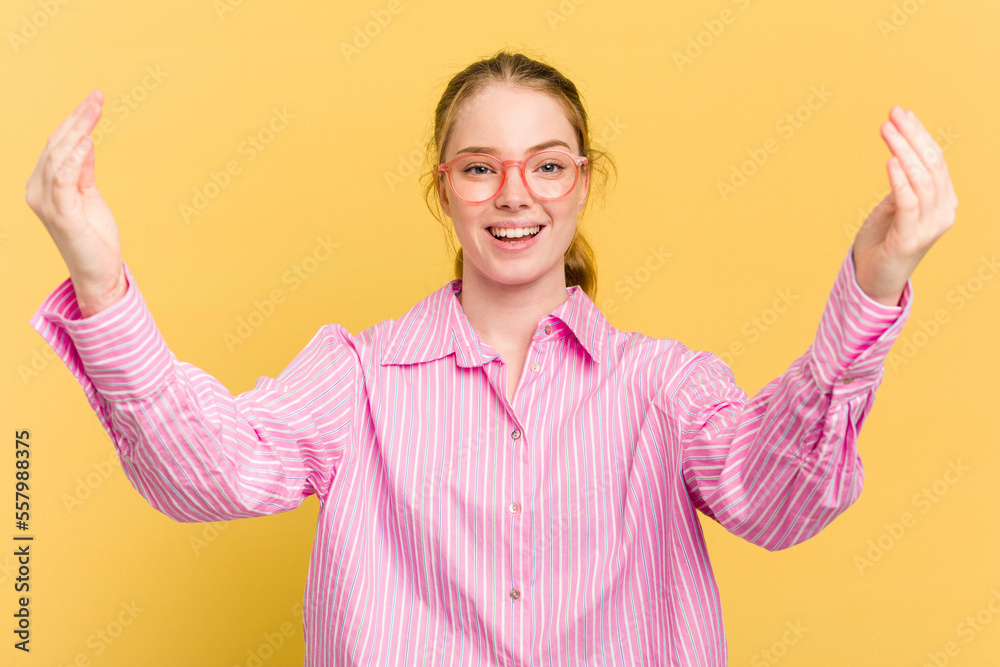 Young caucasian redhead woman isolated on yellow background celebrating a victory or success, he is surprised and shocked. Young caucasian redhead woman isolated on yellow background celebrating a victory or success, he is surprised and shocked.